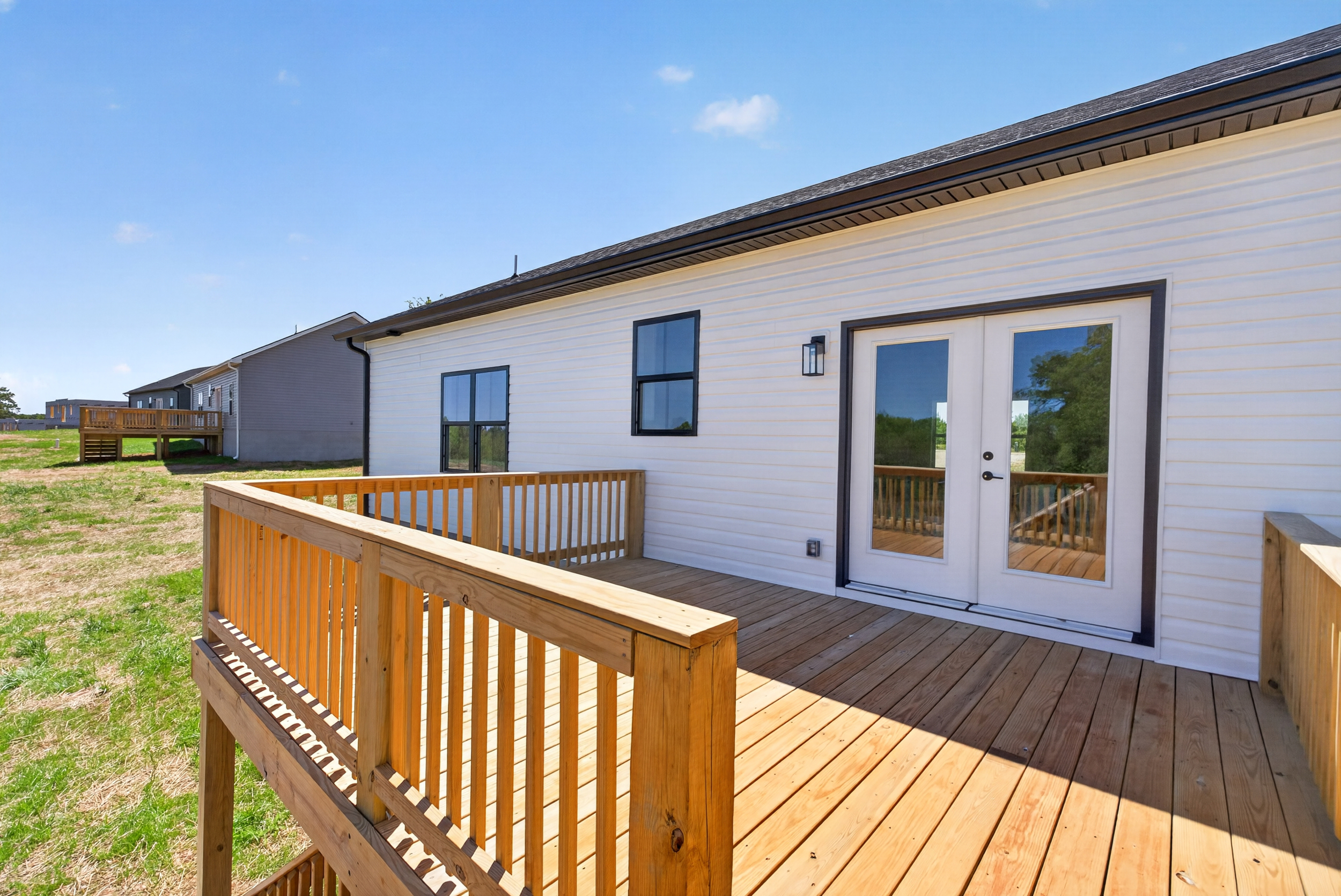Home with a wooden deck on a sunny day.
