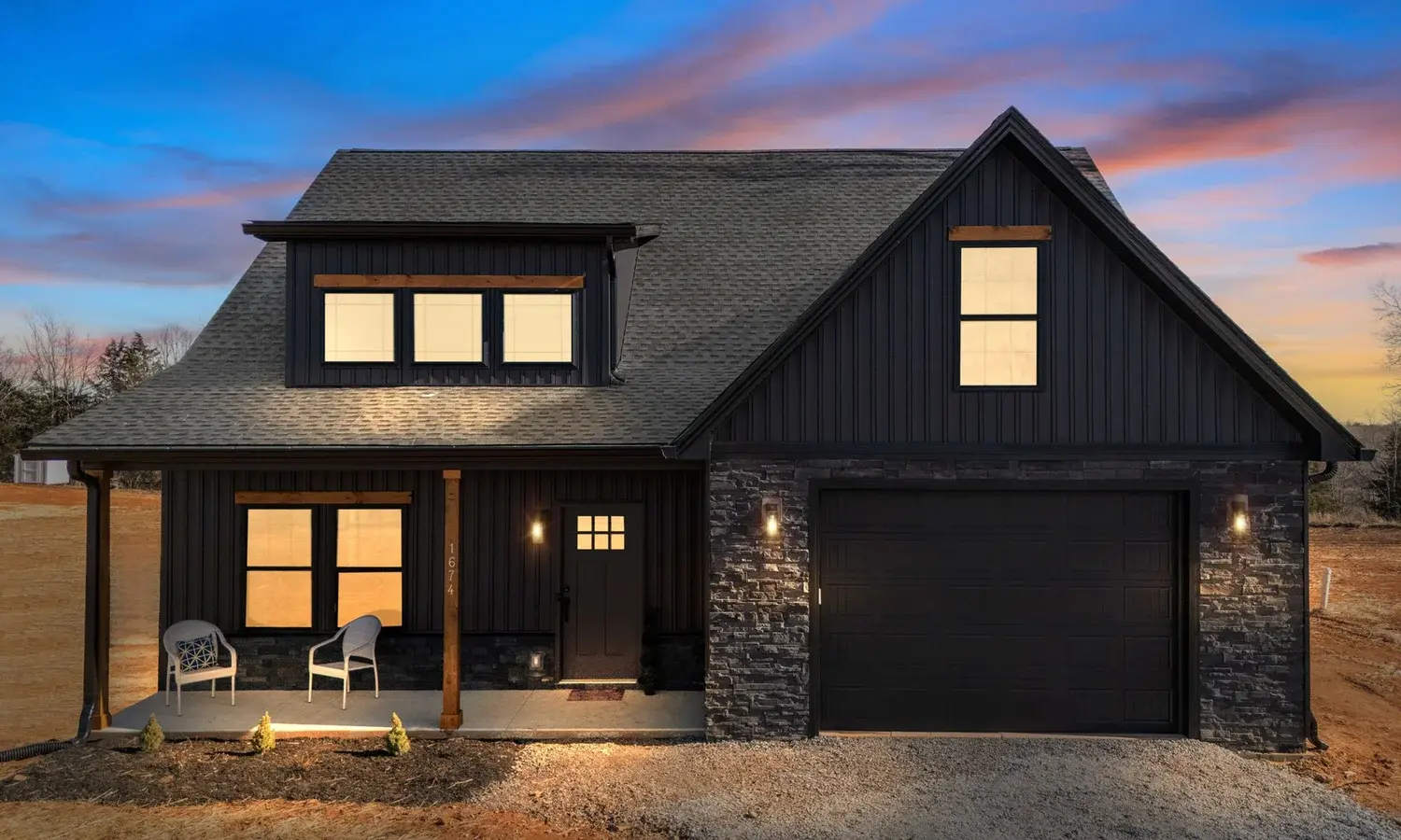 Front exterior of the Crab Orchard floor plan at night with lit entryway and gabled roofline